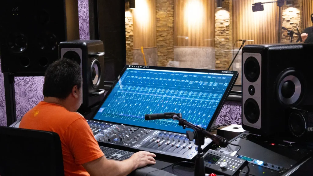 Technician working on a mixing console in a professional audio recording studio in Houston during a session